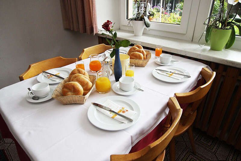 Gedeckter Frühstückstisch mit Semmerln und Säften