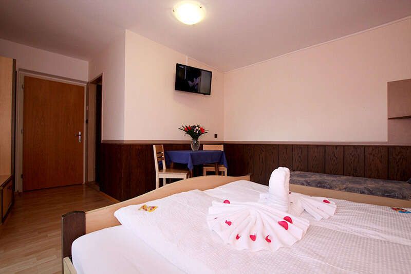 Familienzimmer mit TV und Tisch mit Stühlen