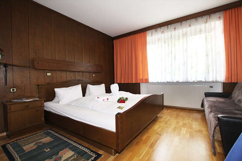 Doppelbettzimmer mit dunkler Holzvertäfelung