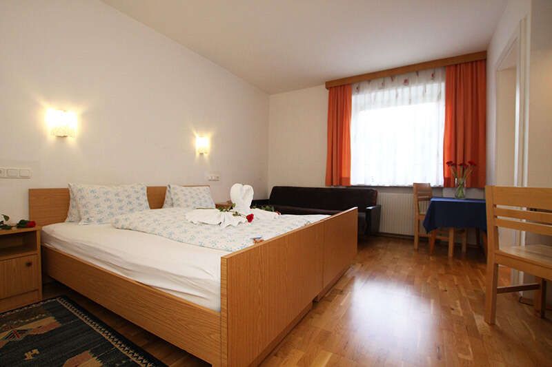 Doppelbett mit Couch und Tisch mit 2 Stühlen